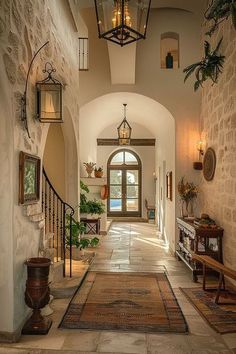 an entry way with stone walls and arched doorways leading to another room that has potted plants on either side of the door