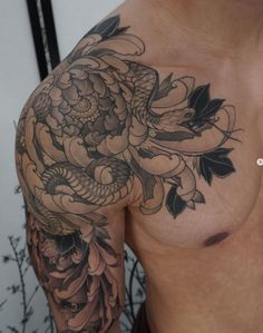 a close up of a person with a tattoo on his arm and chest holding a cell phone