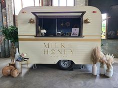 an old trailer is decorated with flowers and other items for sale in the store's lobby