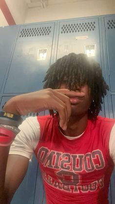 a person with dreadlocks standing in front of lockers