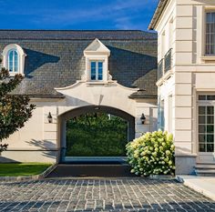 a large white house with a stone driveway