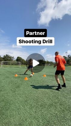 two men are playing soccer on the grass with orange balls in front of them and one man is about to kick an orange ball