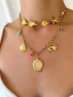 Experience the perfect combination of beachy charm and Greek craftsmanship with our Gold Summer Shell Necklace. Made with vibrant enamel stones and durable stainless steel chains, these handmade necklaces embody the essence of summer. The shorter one is designed as a choker, while the longer one features a stunning gold shell charm at the center. Whether worn together or separately, these necklaces are a must-have for any summer lover. Only available at Christina Christi Store. MATERIALS - Metal Italian Summer Jewelry, Trendy Beach Jewelry With Charms, Beach Metal Choker Necklaces, Multicolor Beach Jewelry With Charms, Beach Metal Choker Necklace, Metal Choker Necklaces For The Beach, Summer Beach Metal Necklace, Metal Necklace With Starfish Charm For Gift, Metal Choker For Beach