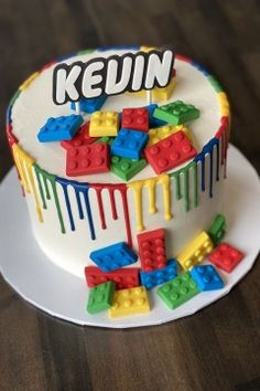 a cake decorated with legos and the words kevin painted on it's side