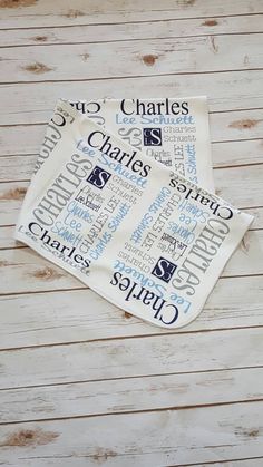 two personalized tea towels with names on them sitting on top of a wooden table