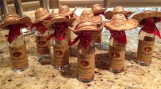 six empty wine bottles with straw hats on them