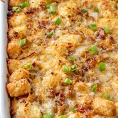 a casserole dish with chicken, cheese and green onions in it on a table