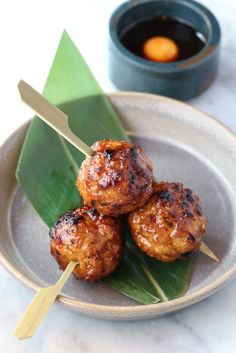 some meatballs are on a plate with a green leaf