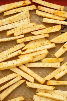 seasoned french fries on a baking sheet ready to be baked in the oven for dinner