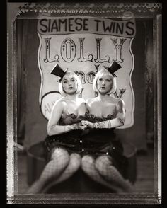 two women sitting on top of each other in front of a sign that says same twins holly