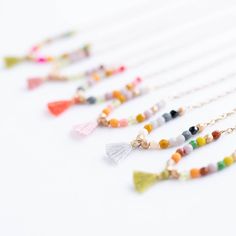 This beautiful necklace is guaranteed to turn heads! Delicate and dainty, its 16" of tiny 3mm czech glass beads are expertly woven to an antique gold plated chain and finished with an oh-so-fashionable tassel at its center. Elegant, eye-catching, and utterly unique—this necklace is the perfect finishing touch to any outfit! Choose from 5 colors: Coral Tassel: Red, mustard, pink, coral, aqua, grey, and gold beads Moss green Tassel: brown, gold, chartreuse, green, lilac, brown, pumpkin, moss, gold Indie Craft, Pink Tassel, Spring 2023, Travel Jewelry, Beautiful Necklace, Gold Plated Chains, Pop Up Shop, Amethyst Crystal, Czech Glass Beads