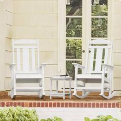 two white rocking chairs sitting on top of a wooden porch