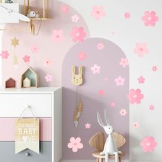 a child's room with pink flowers on the wall and a white rabbit statue