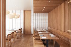 an empty restaurant with wooden tables and benches in front of the wall, along with hanging lights