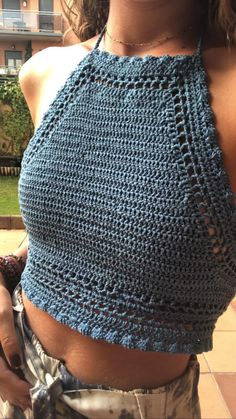 a woman wearing a blue crocheted crop top