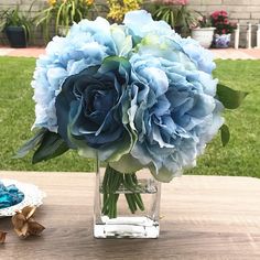 a vase filled with blue flowers on top of a wooden table