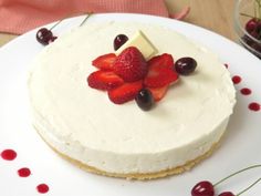 a cake with white frosting and strawberries on the top is sitting on a plate