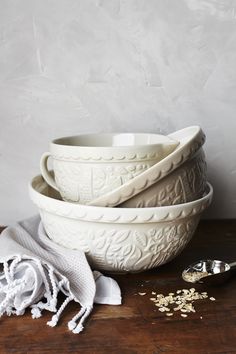 three white bowls with spoons next to each other