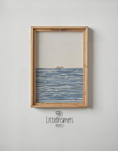 a wooden frame hanging on the wall above a blue and white striped piece of artwork