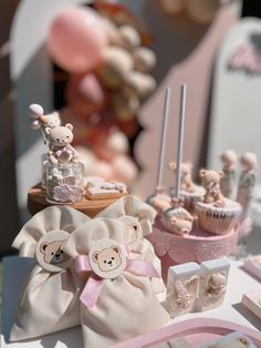 there are many small teddy bears on the table with cupcakes and other decorations