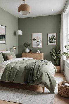 a bed sitting in a bedroom next to a window covered in green blankets and pillows