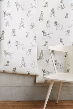 a white chair sitting next to a wall with dogs on it