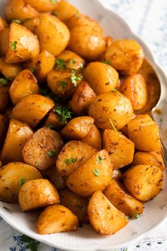 a white bowl filled with cooked potatoes on top of a table