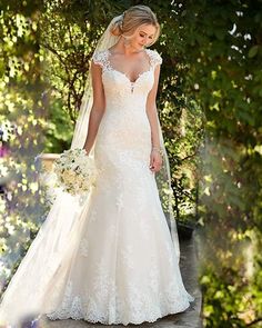 a woman in a wedding dress standing outside