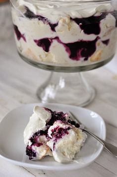 a white plate topped with a dessert next to a glass bowl filled with ice cream