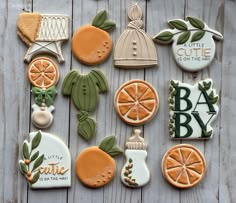 decorated cookies are arranged on a wooden surface with the words little cutie for the baby