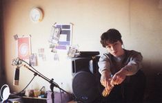 a young boy sitting in front of a desk with a microphone and sound equipment on it