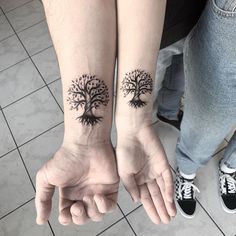 two people with matching tattoos on their arms