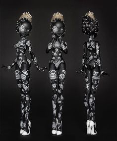 three black and white figurines standing next to each other on a black background