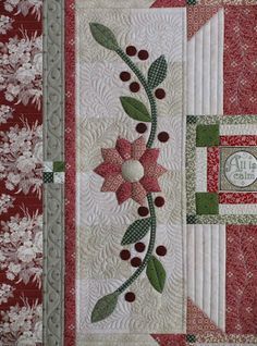 a quilted wall hanging with flowers and leaves on it