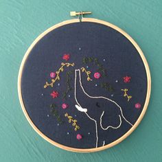 a embroidery hoop with a giraffe and flowers on it