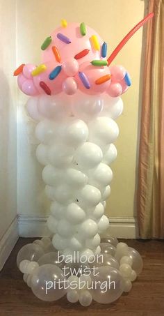 an ice cream cone filled with sprinkles and balloons