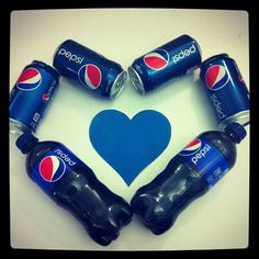 six pepsi cans arranged in the shape of a heart