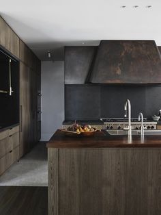 a modern kitchen with stainless steel appliances and wood countertops, along with an island