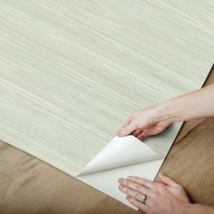 a woman is making a rug on the floor with her hands and glues it together