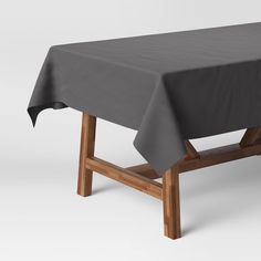 a table with a gray cloth on it and some wooden legs in front of the table