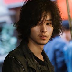 a young man standing under an umbrella in the rain