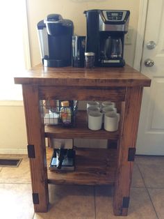 a small wooden table with coffee maker and cups on it