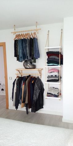 an open closet with clothes hanging on the wall