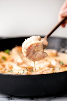 a person is spooning some food out of a skillet