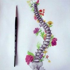 a drawing of a skeleton with flowers on it and a pen next to it, sitting on top of a piece of paper