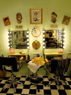 a hair salon with chairs and mirrors in front of the lights on the wall above them