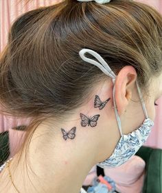 a woman with a butterfly tattoo behind her ear