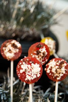 several lollipops with white and red toppings on them