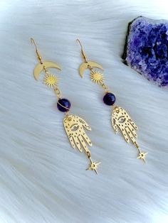 These egyptian grunge hamsa hand earrings are made to protect you from the evil eye and keep out all negative or jealous energy from your life.  Amethyst is a powerful protective and healing stone. It balances your mood, heals and protects your energy aura and adds uplifting energy. It is associated with the crown and third eye chakras, of wisdom and intuition.  Amethyst is associated with spirituality, protection and intuition. It helps to open your third eye and bring peace, clarity and positi Mystical Metal Earrings For Festivals, Symbolic Dangle Plug Earrings For Pierced Ears, Mystical Drop Earrings For Festival, Symbolic Dangle Earrings For Festivals, Mystical Metal Pierced Earrings, Handmade Spiritual Metal Plug Earrings, Energy Aura, Open Your Third Eye, Witchy Style