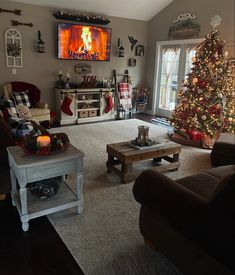 a living room filled with furniture and a christmas tree in front of a flat screen tv